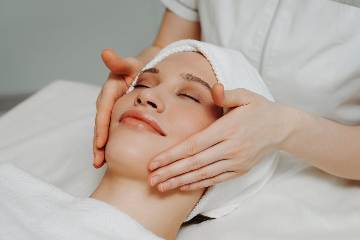 Woman receiving a relaxing facial massage treatment at a luxury spa